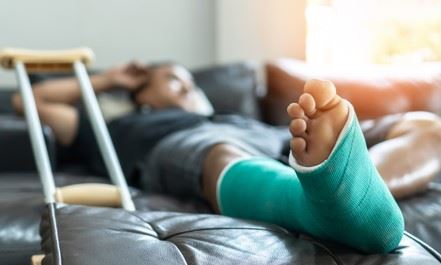 man with a broken leg in a cast laying on a couch
