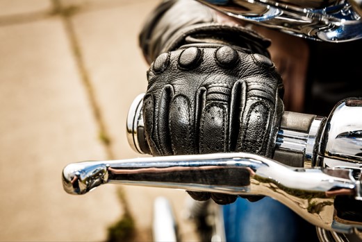 biker gripping motorcycle handlebars with glolves