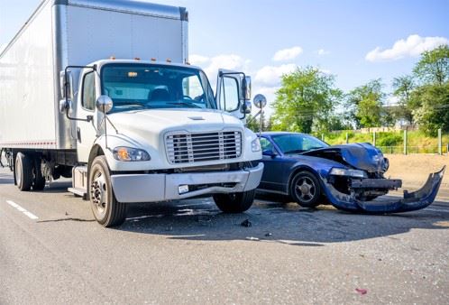 damaged passenger car next to semi truck on highway