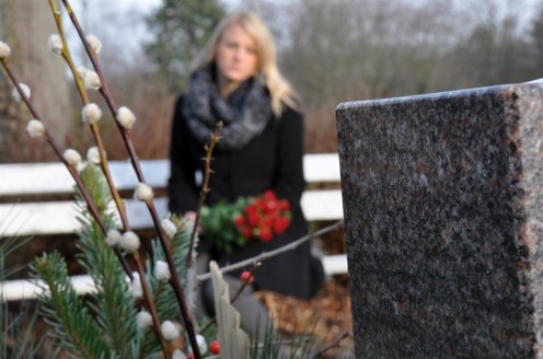 sad woman kneeling at graveside